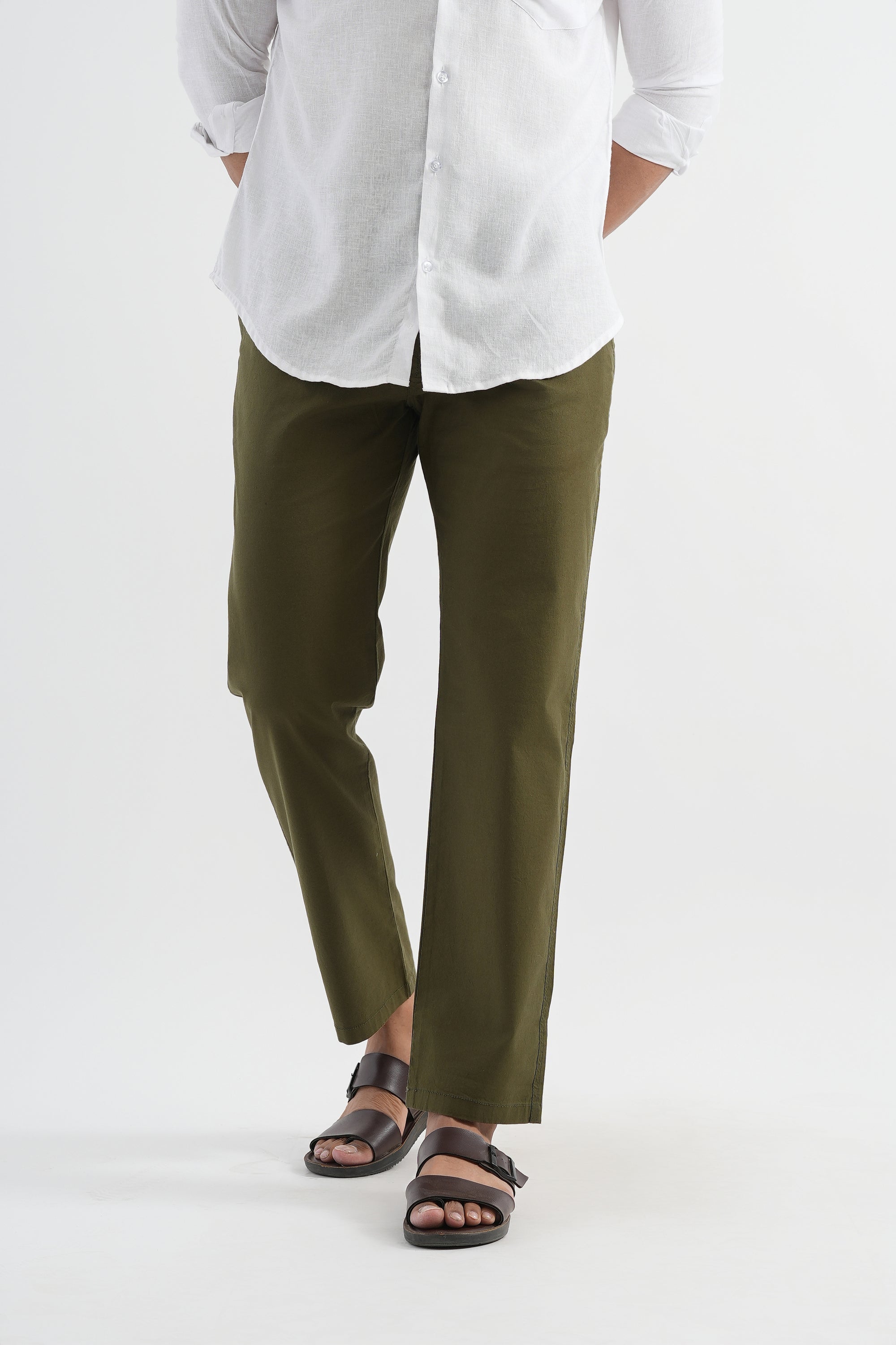 Person wearing a white shirt and green pants on a white background
