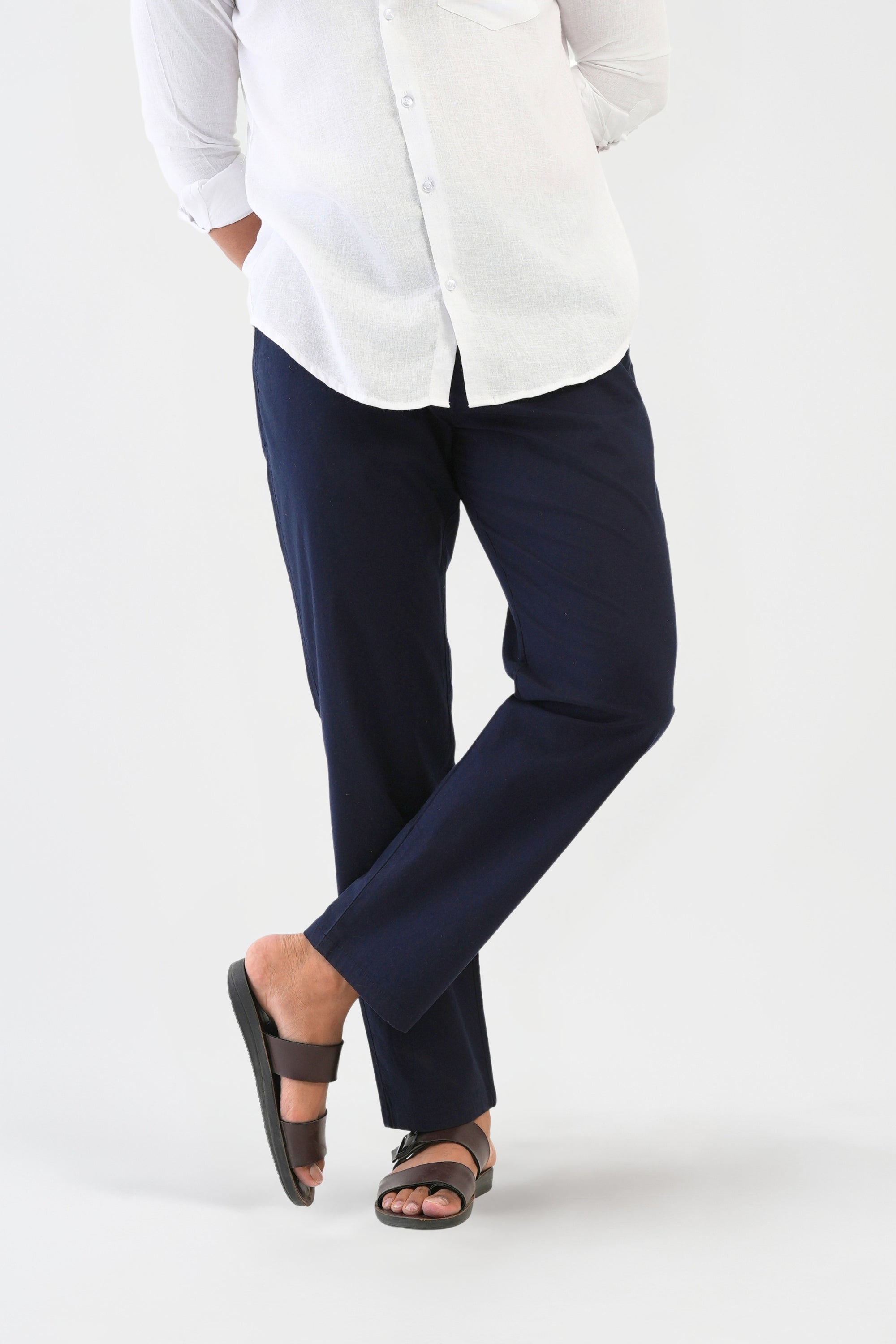 Person wearing a white shirt and navy pants on a white background