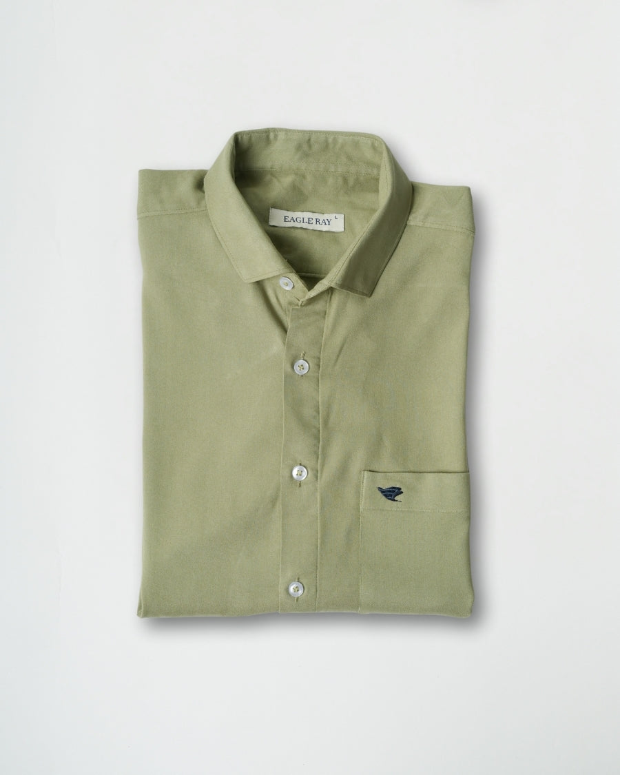 Folded green shirt with a brand label on a light gray background