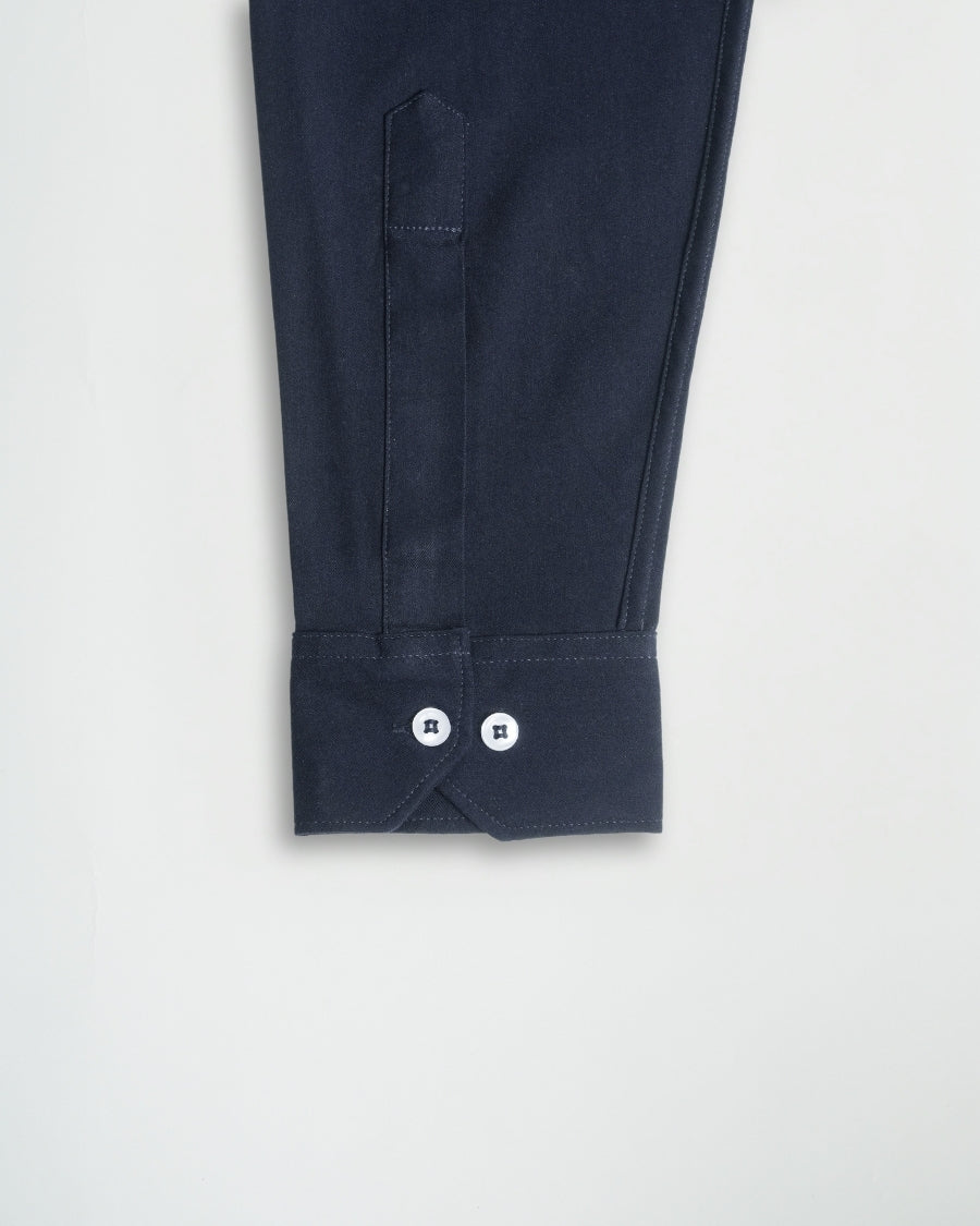 Navy blue pants with button details on a light gray background