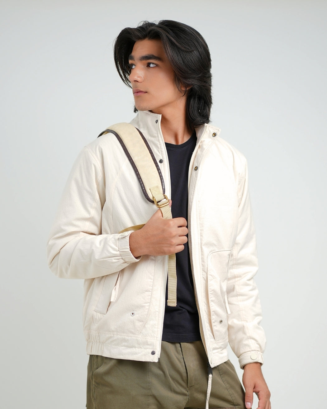 Person wearing a white jacket with a hood on a plain background