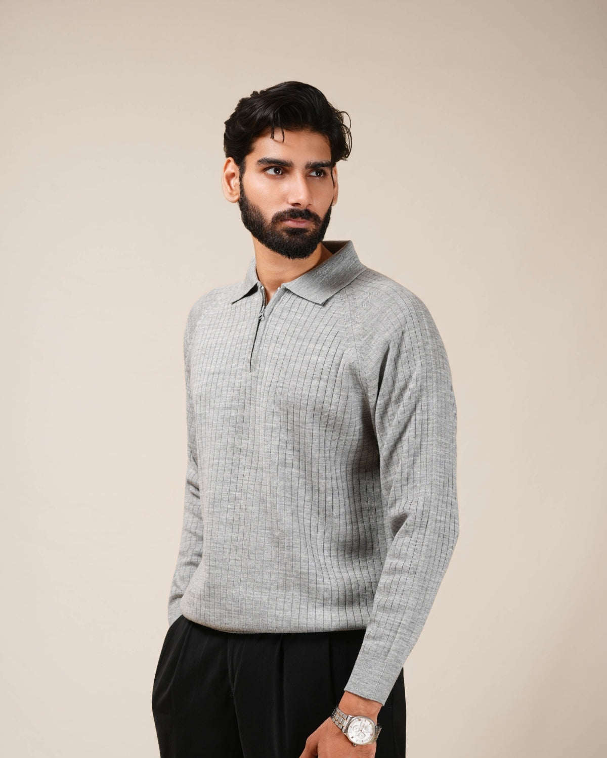 Man wearing a gray checkered sweater against a beige background