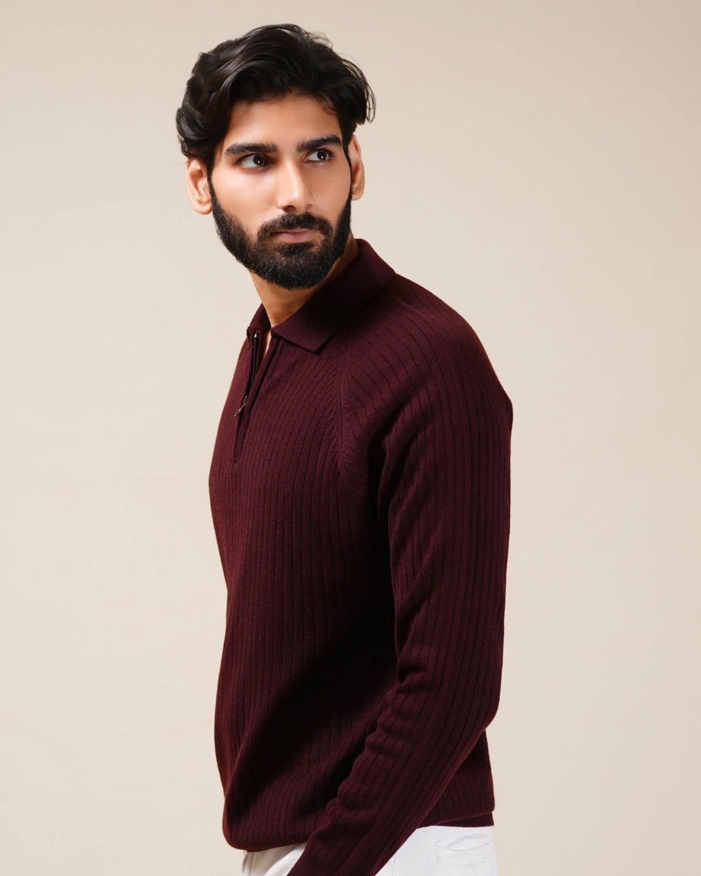 Man wearing a burgundy sweater against a beige background
