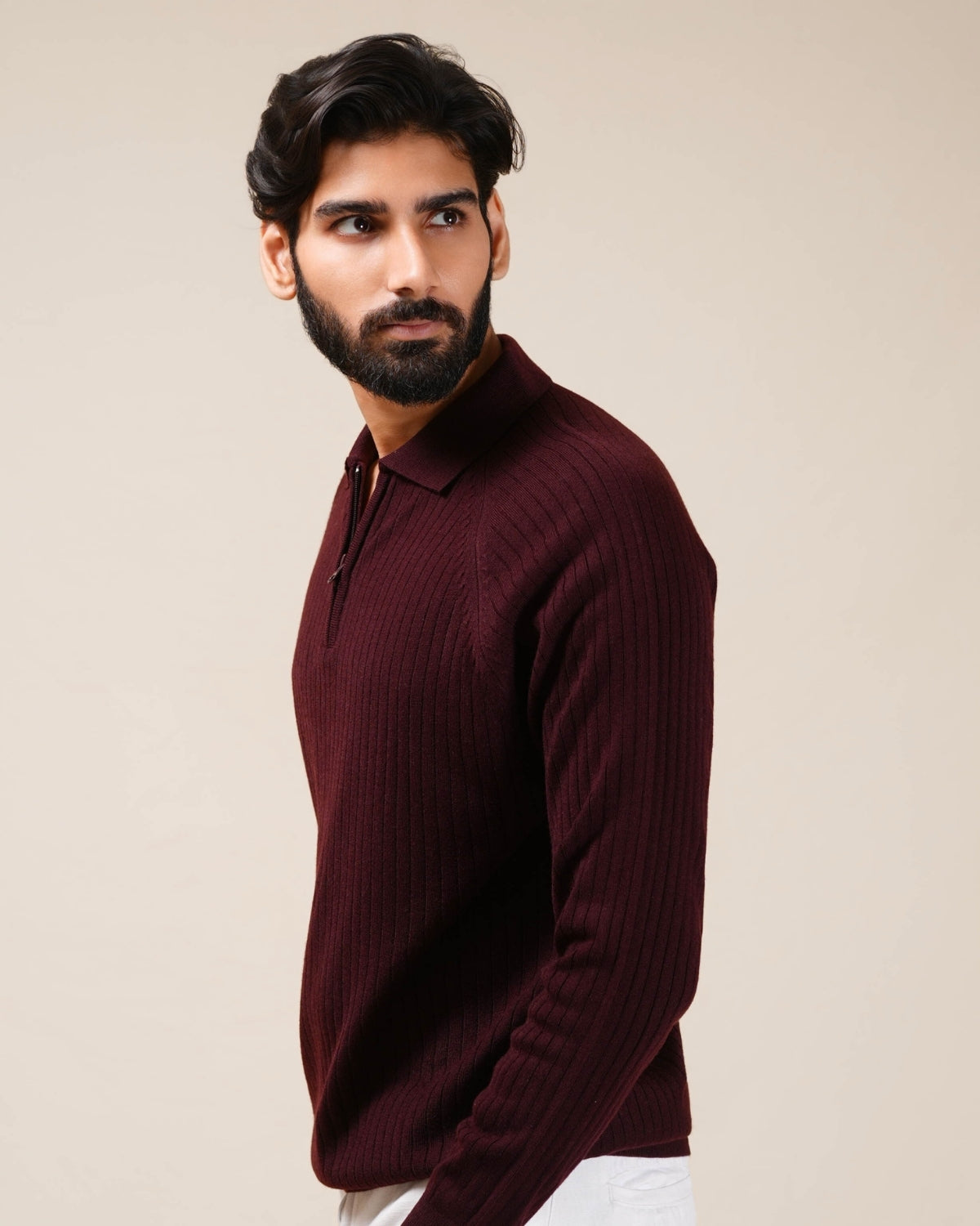 Man wearing a burgundy sweater against a beige background