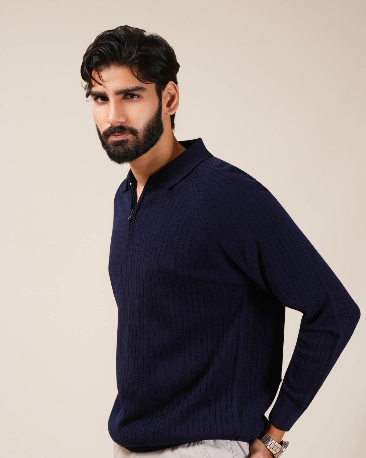 Navy ribbed sweater with a quarter zip on a neutral background