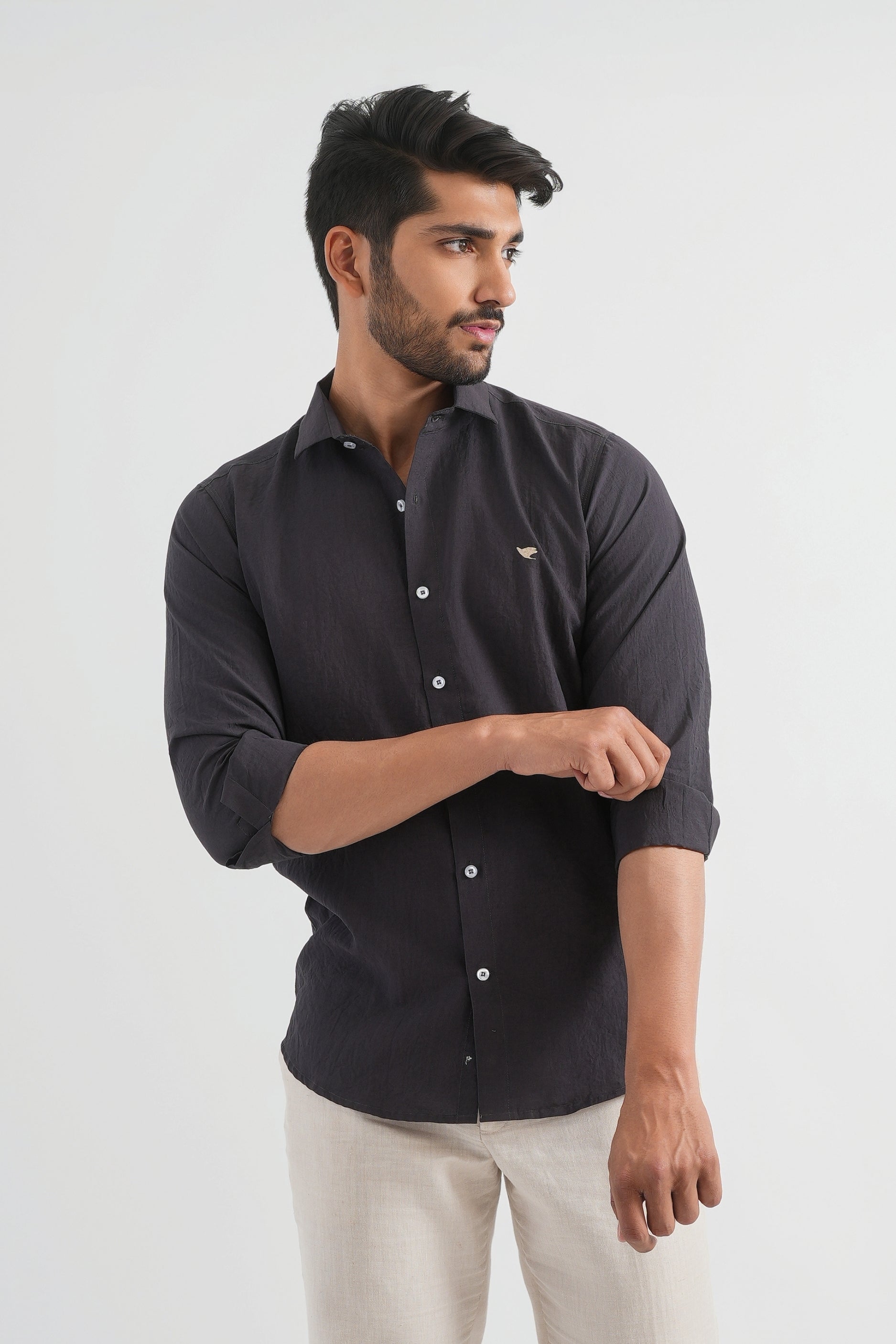 A man wearing a dark grey long-sleeved crushed cotton shirt with the collar visible and a button-up front.