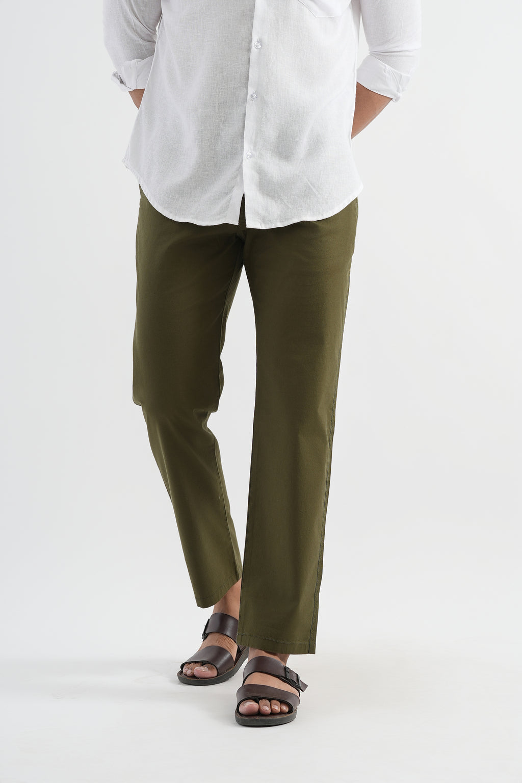 Person wearing a white shirt and green pants on a white background