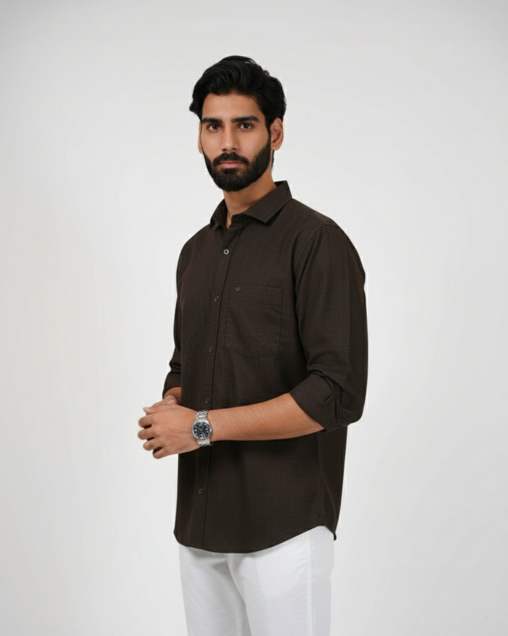 Man wearing a brown shirt and white pants on a plain background