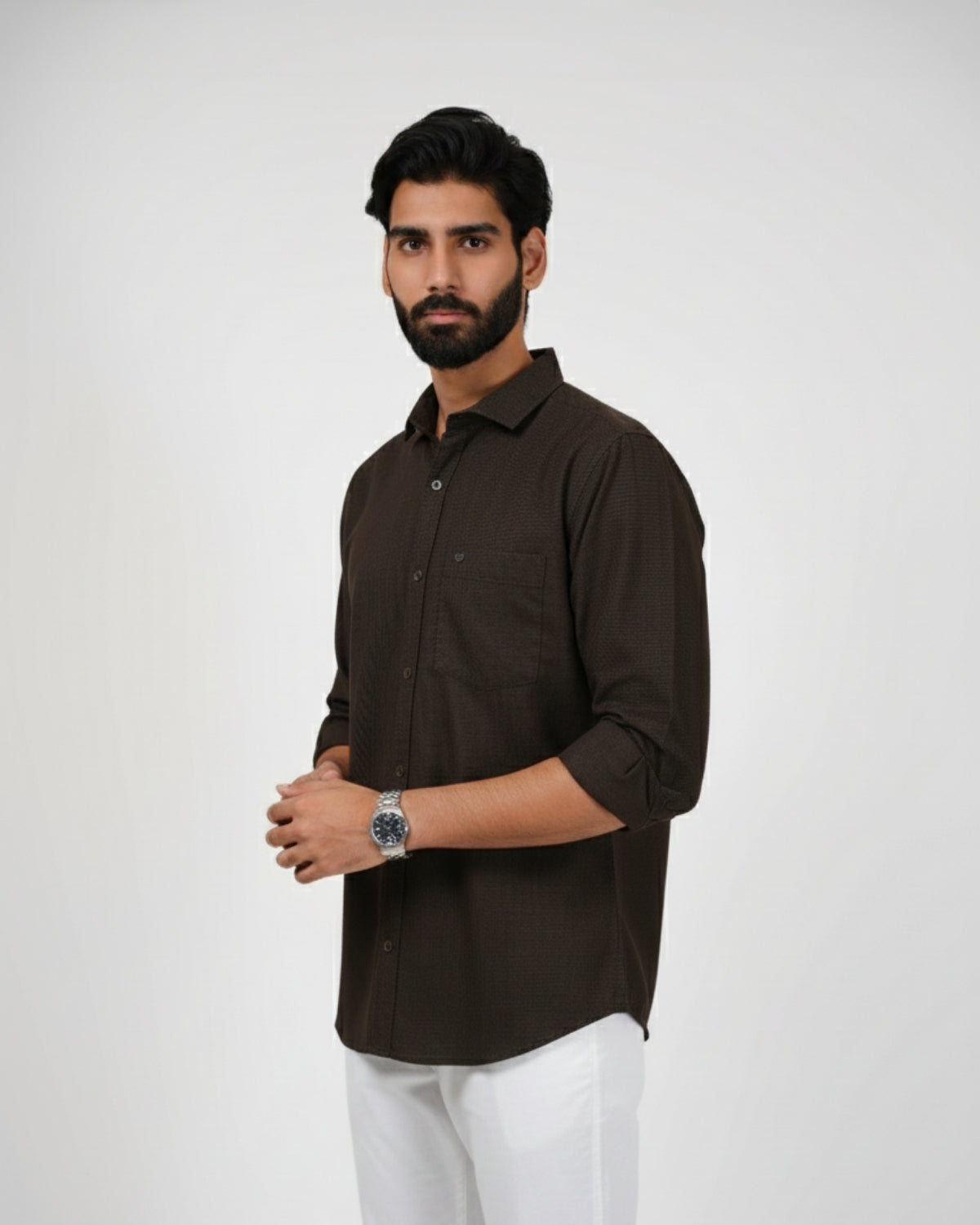 Man wearing a brown shirt and white pants on a plain background