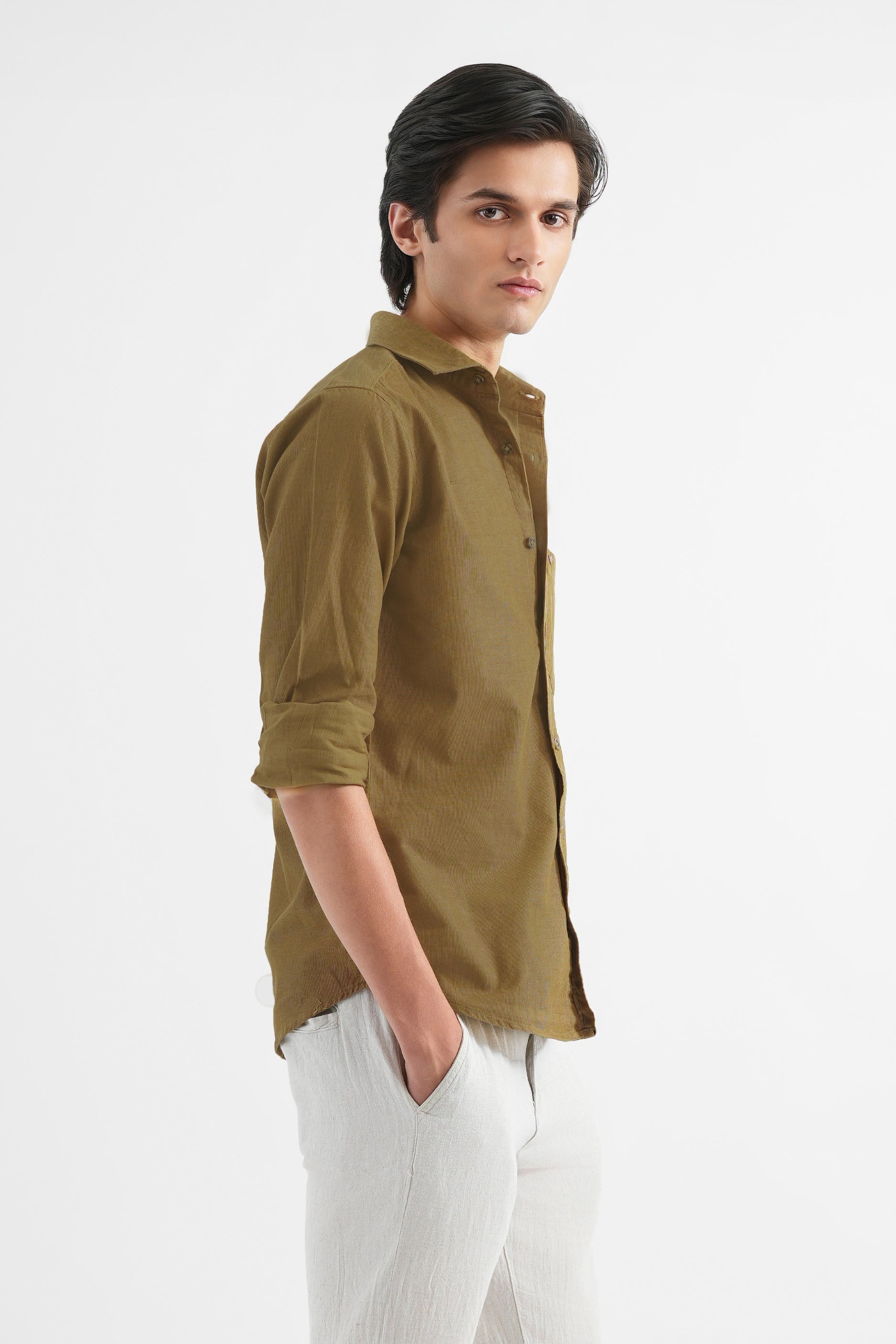 Man wearing a green shirt and white pants on a white background