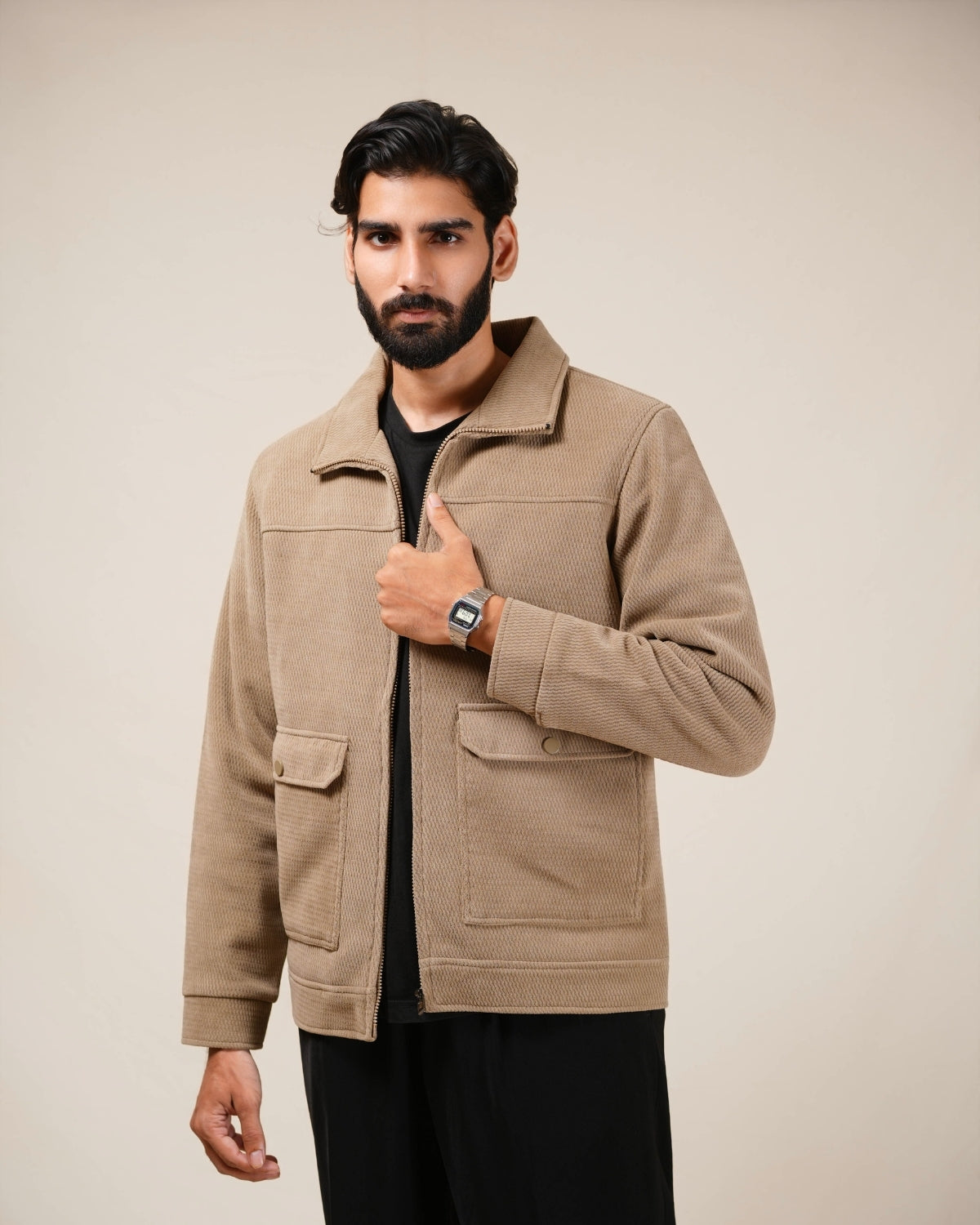 Man wearing a beige jacket against a plain background