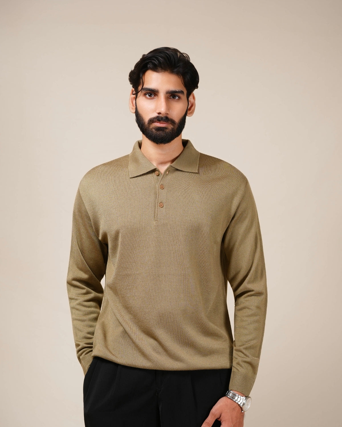 Close-up of a person wearing a brown polo shirt with a neutral background
