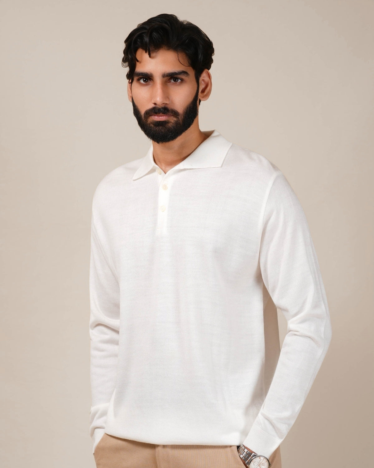 Man wearing a white long-sleeve shirt against a beige background