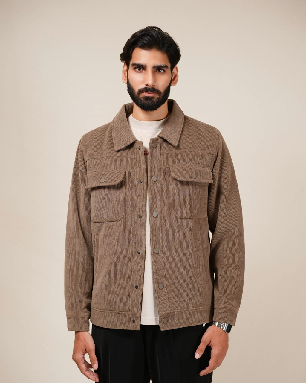 Man wearing a brown jacket against a beige background