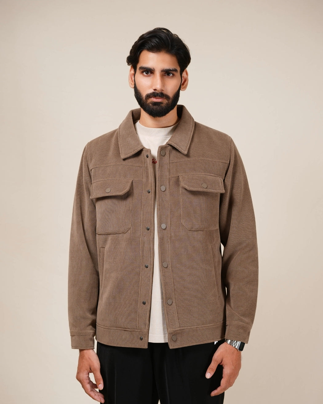 Man wearing a brown jacket against a beige background