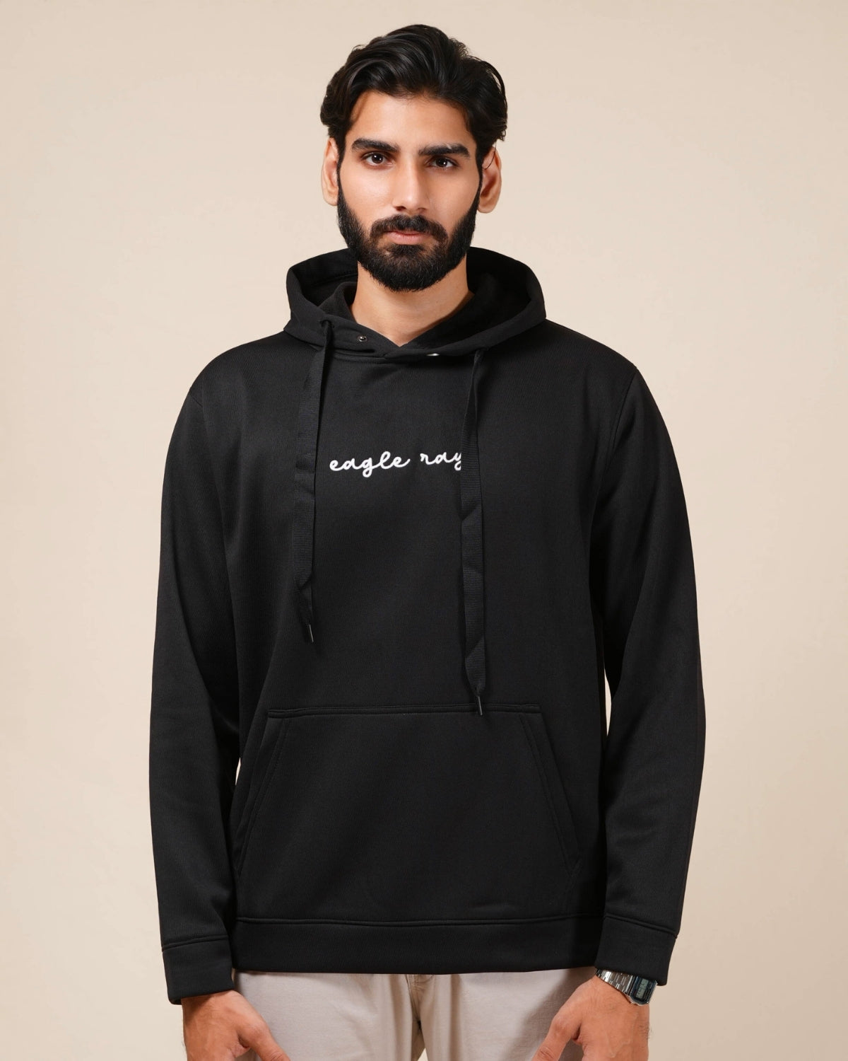 Man wearing a black hoodie with text on a beige background