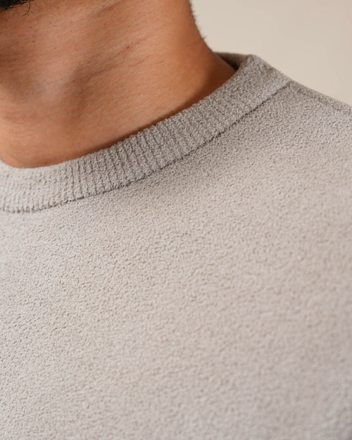 Close-up of a person wearing a textured gray sweater