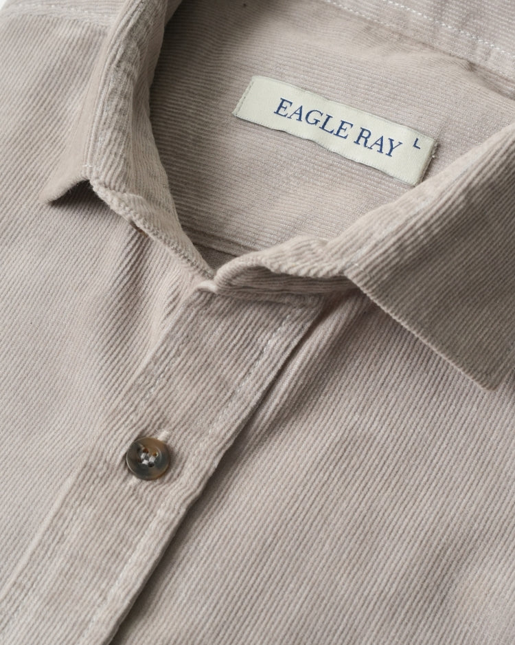 Close-up of a beige corduroy shirt with 'Eagle Ray' label.