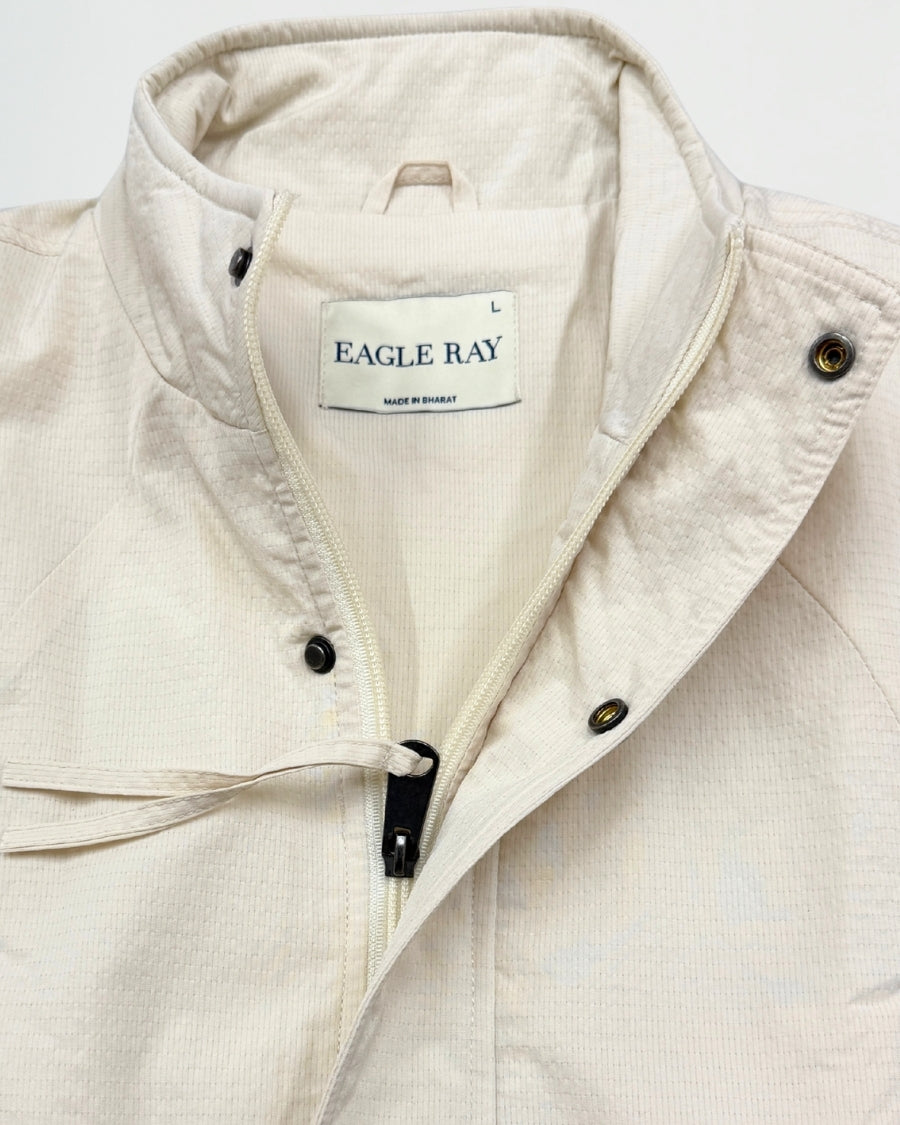 Close-up of a beige jacket with 'Eagle Ray' branding on a white background