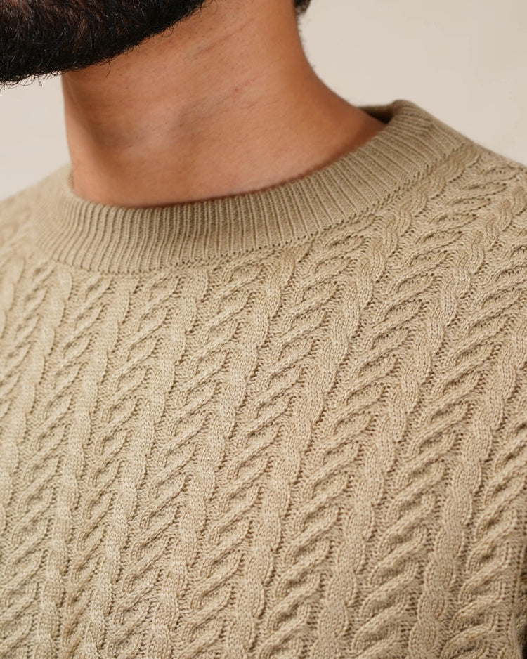 Close-up of a beige cable knit sweater