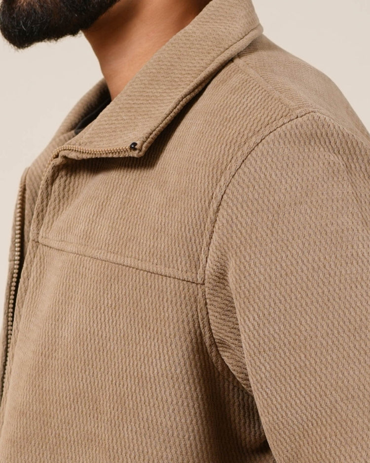 Close-up of a beige textured jacket on a neutral background