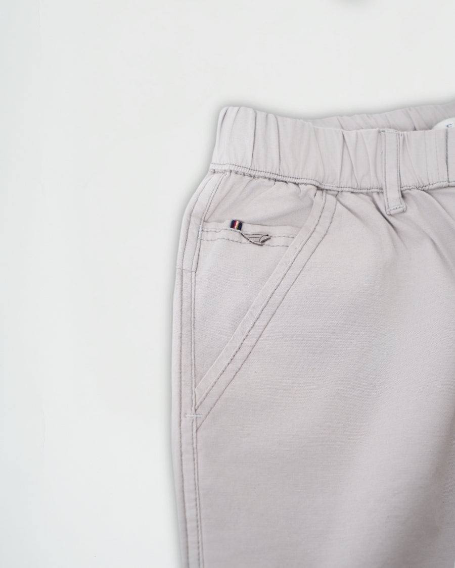 Light gray pants with a brand logo on a white background