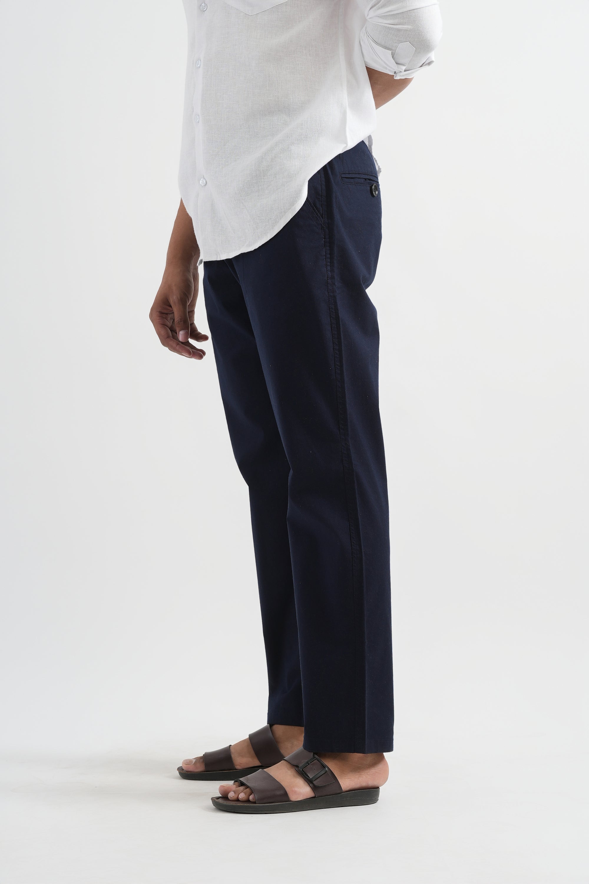 Person wearing a white shirt and navy pants on a white background
