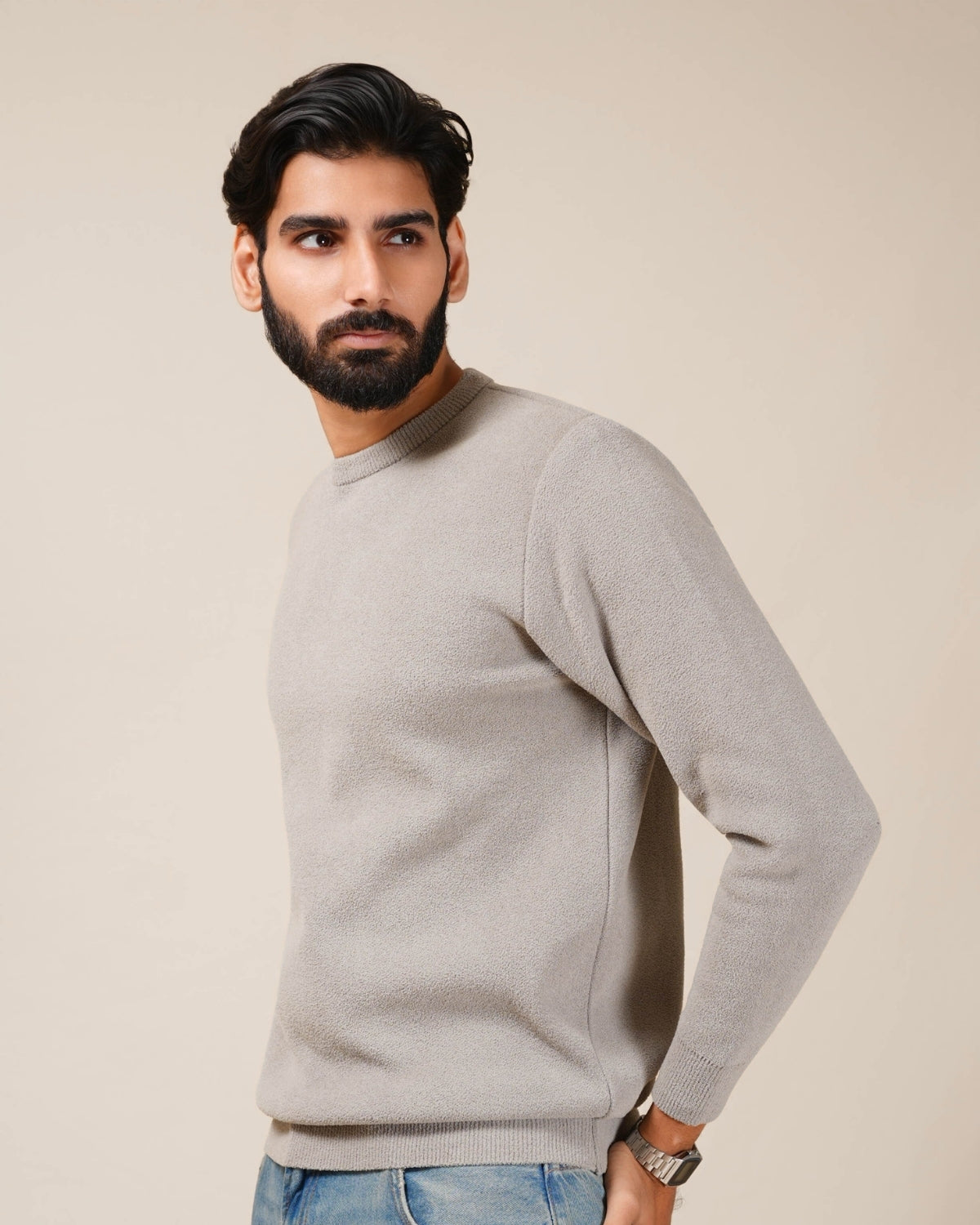 Man wearing a gray sweater against a beige background