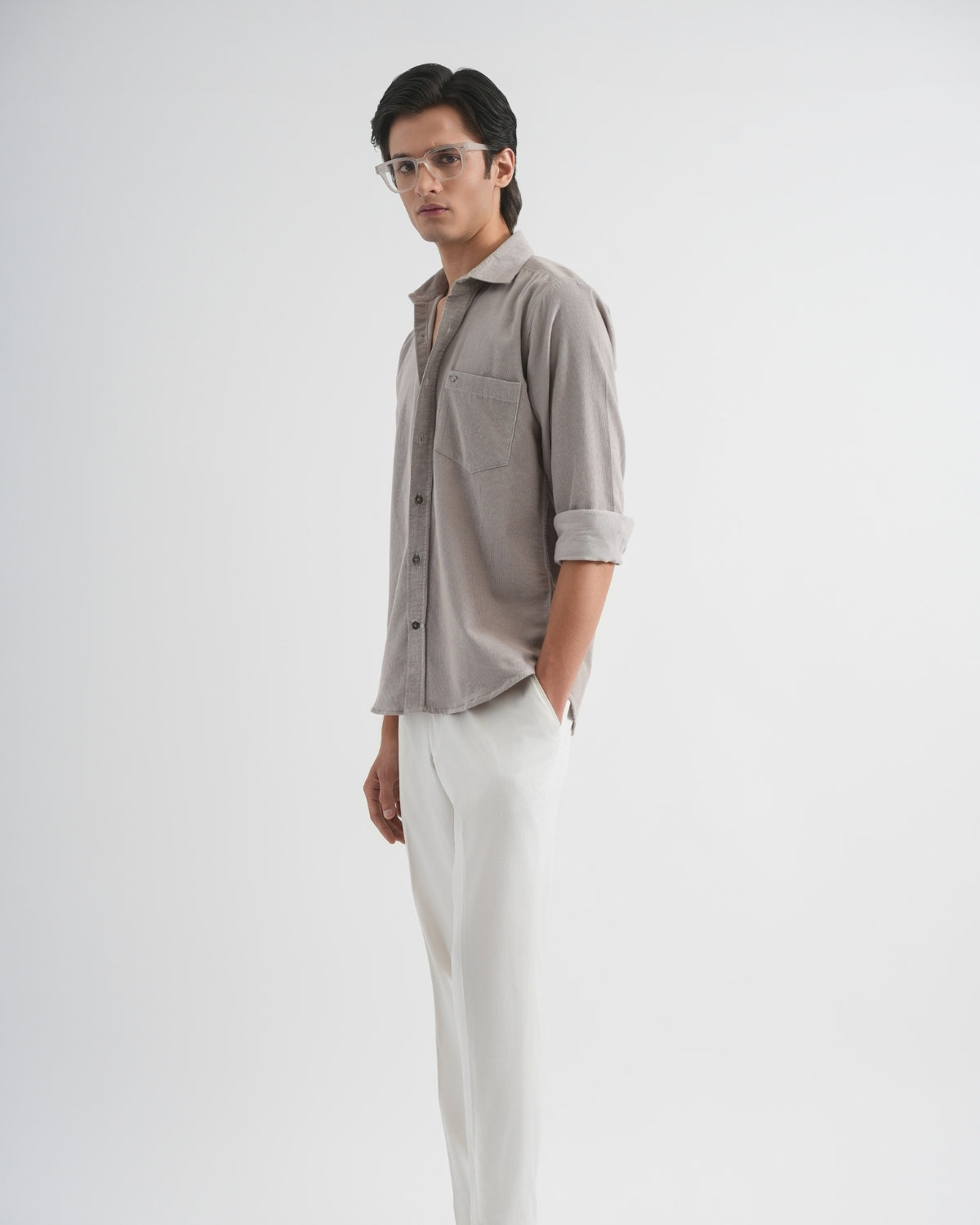 Man wearing a gray shirt and white pants on a white background
