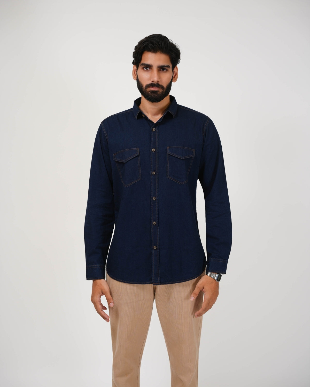 Man wearing a navy blue shirt with two chest pockets on a white background