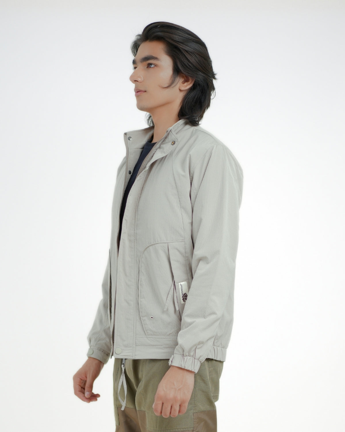 Person wearing a light gray jacket on a white background