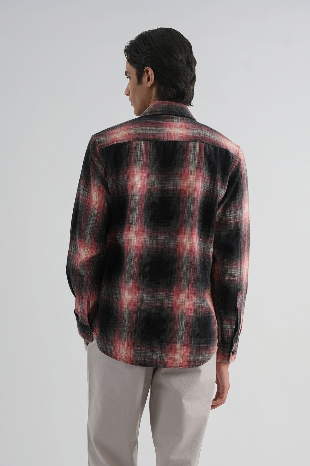 Man wearing a red and black plaid shirt on a white background