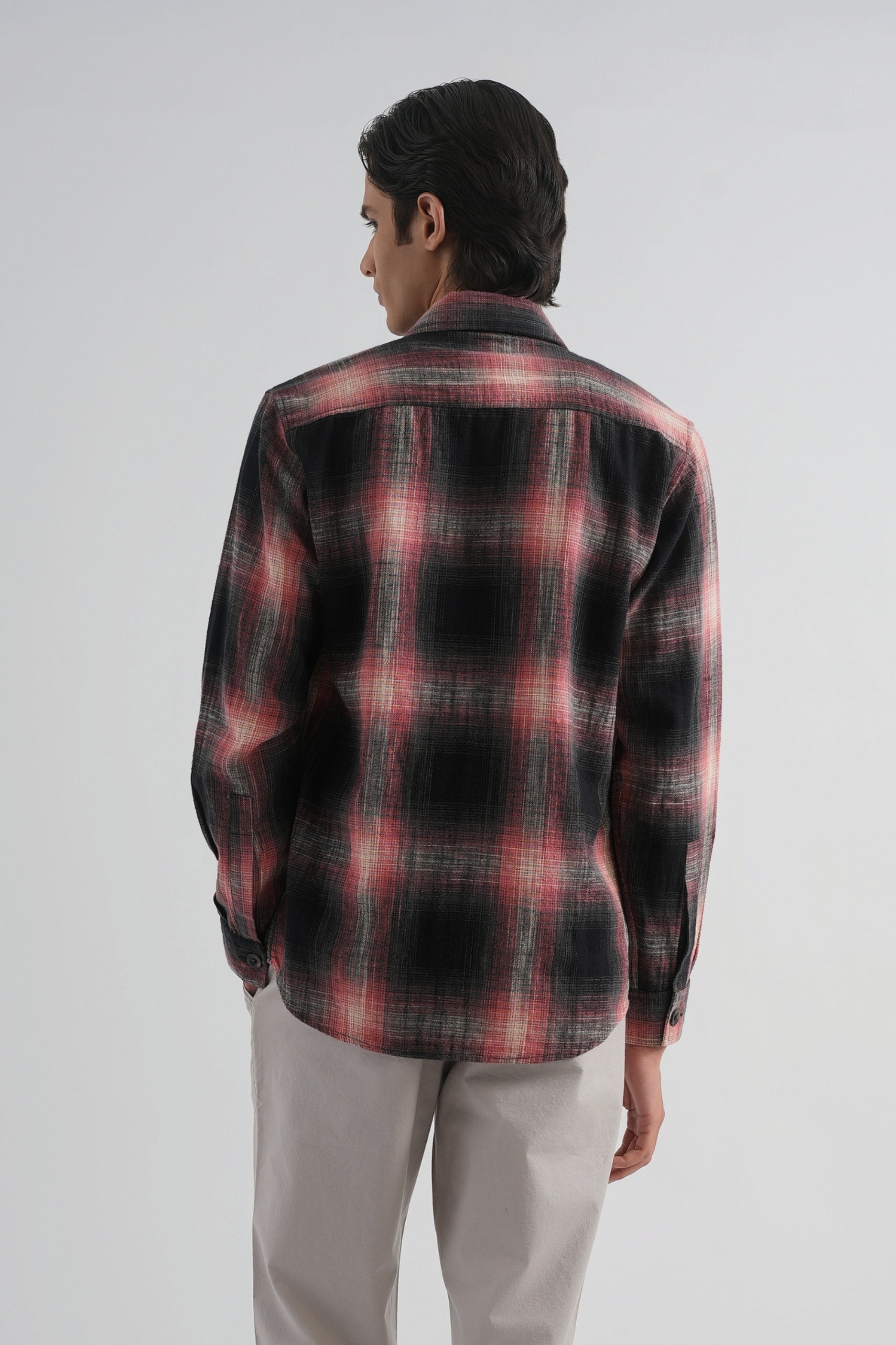Man wearing a red and black plaid shirt on a white background