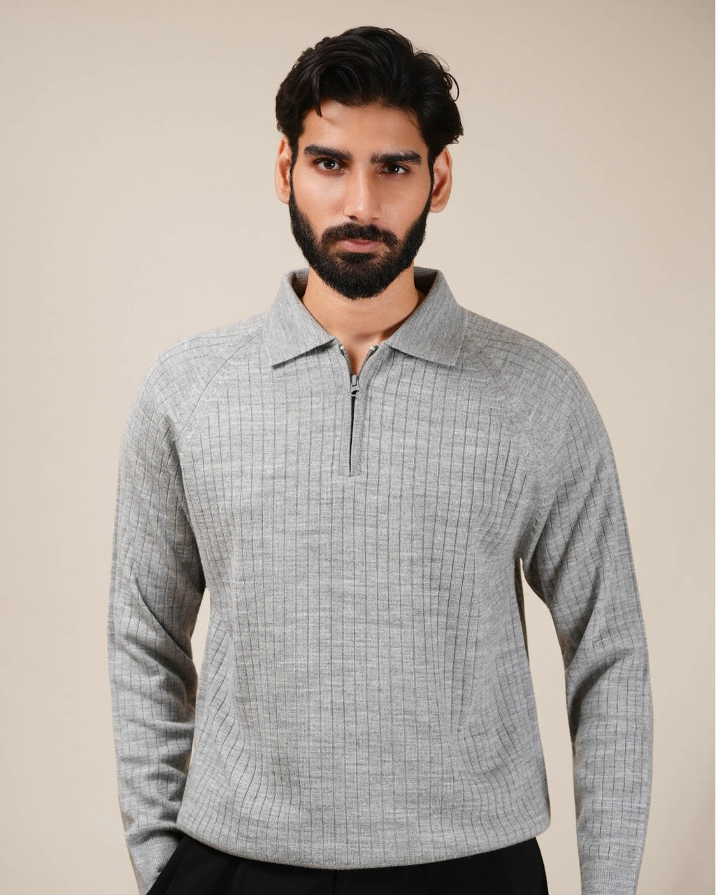 Man wearing a light gray checkered shirt against a beige background