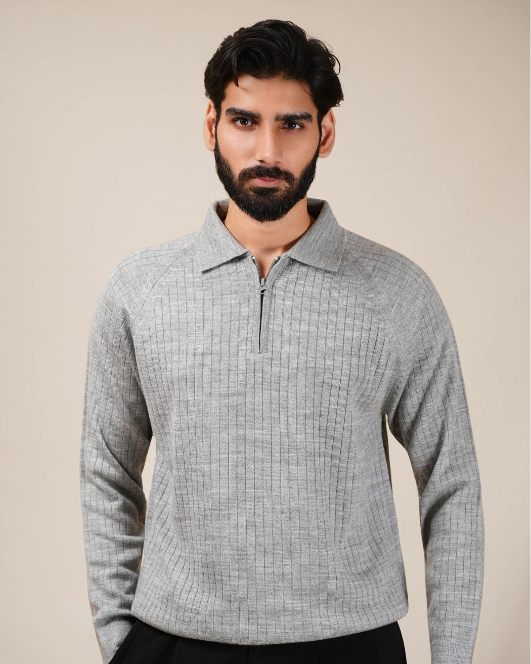 Man wearing a light gray checkered shirt against a beige background