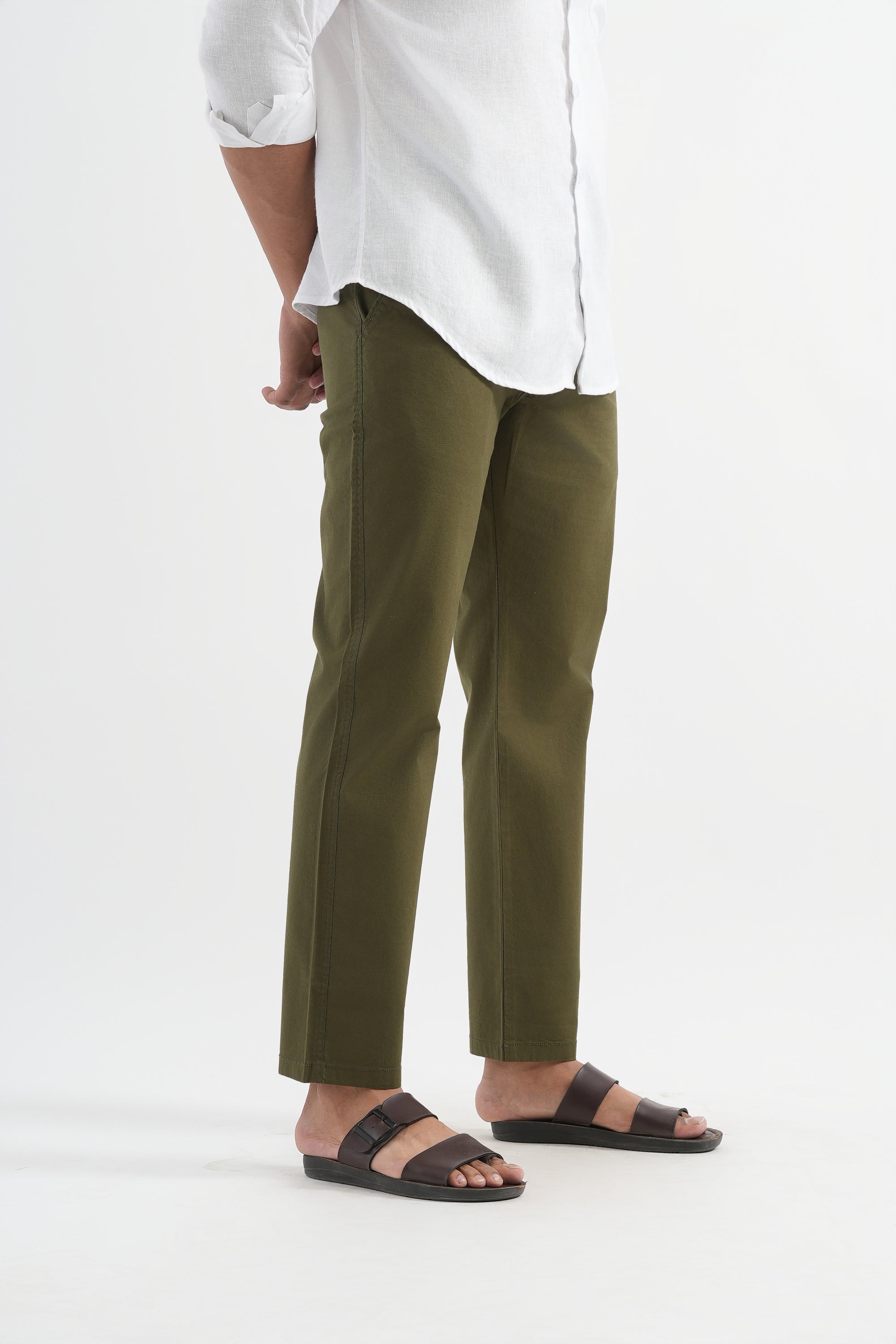Person wearing a white shirt and green pants on a white background