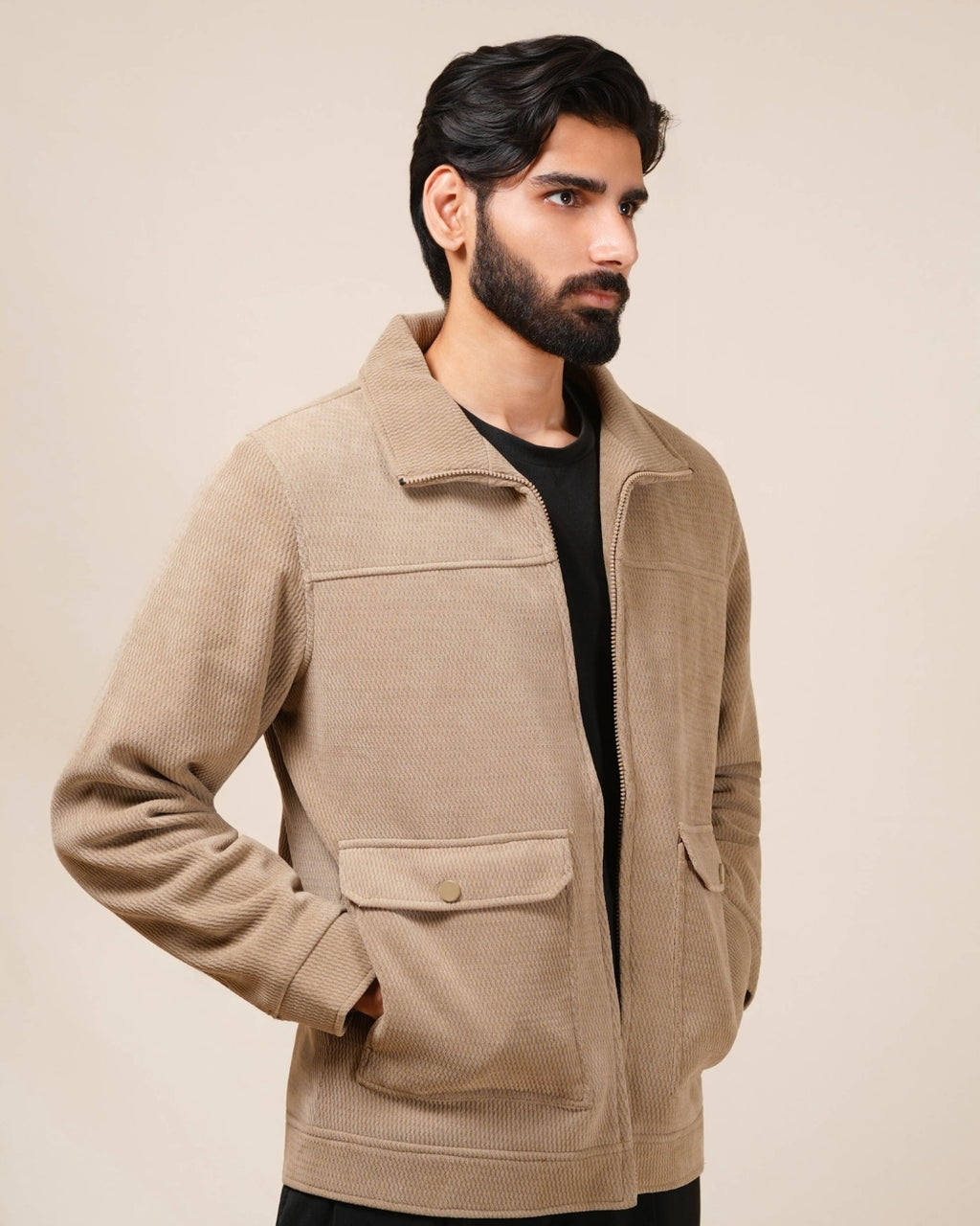 Man wearing a beige jacket against a plain background