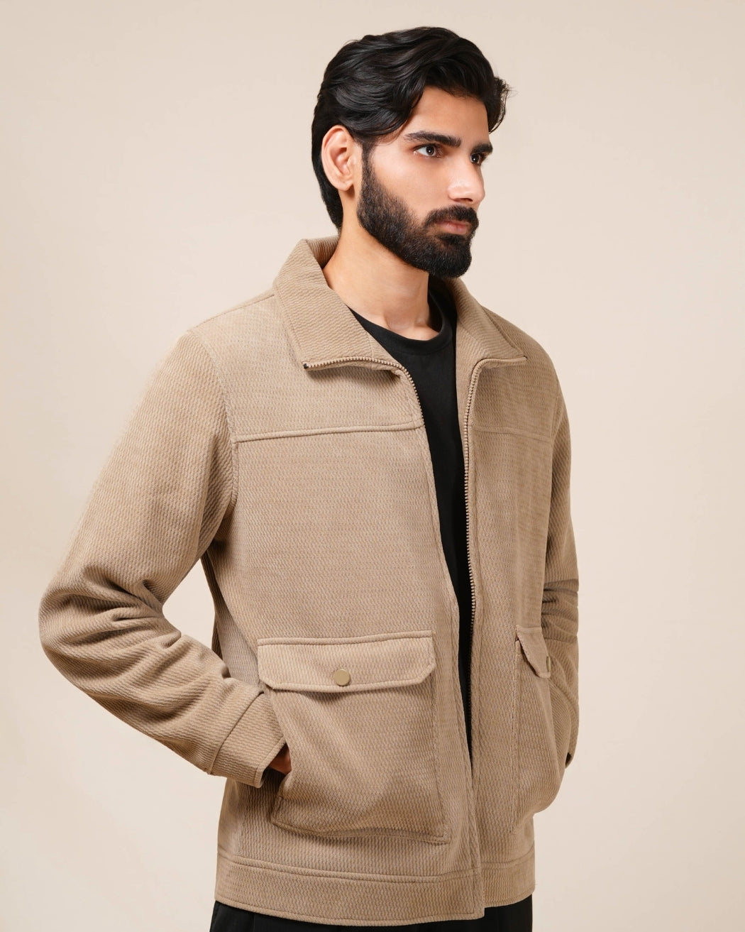 Man wearing a beige jacket against a plain background