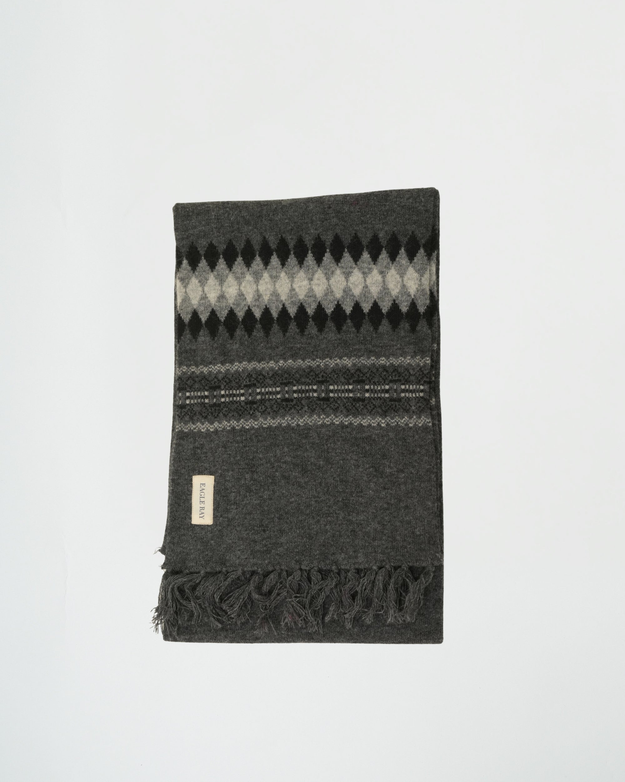 Gray argyle patterned blanket with fringes on a white background