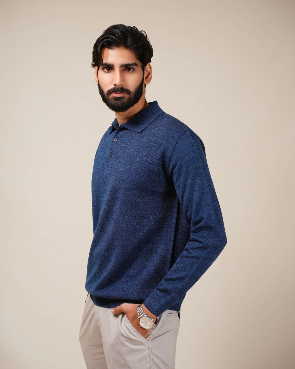 Man wearing a blue long-sleeve shirt against a beige background
