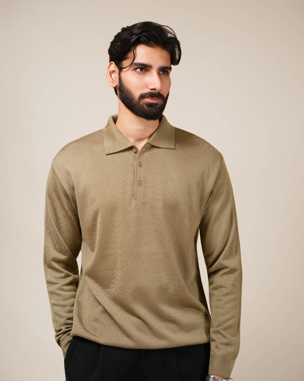 Man wearing a beige long-sleeve polo shirt against a beige background