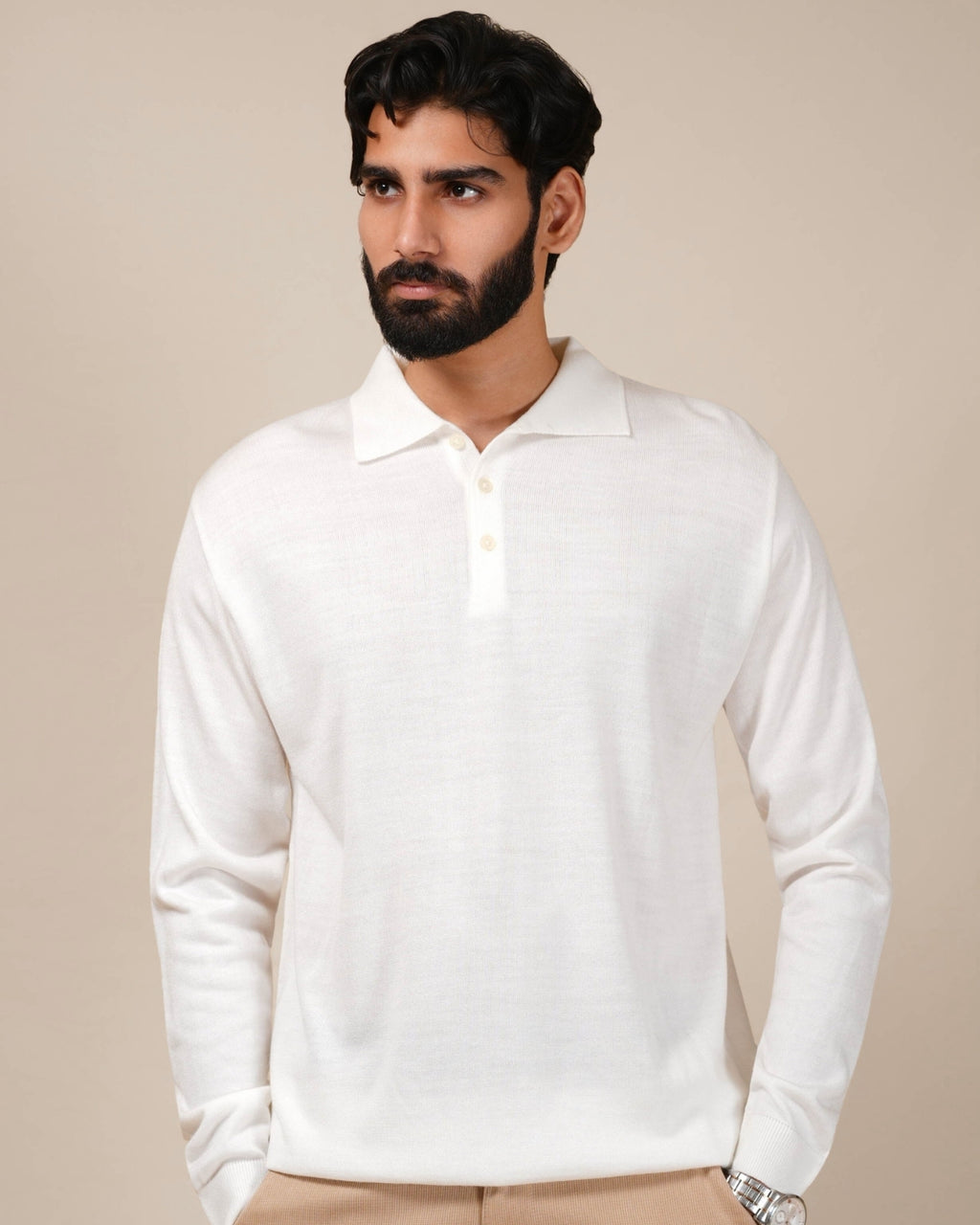 Man wearing a white long-sleeve polo shirt against a beige background