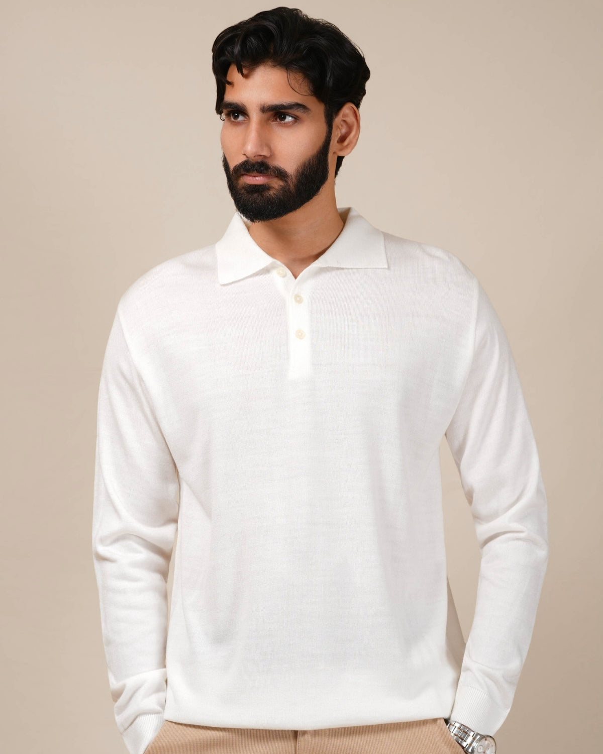 Man wearing a white long-sleeve polo shirt against a beige background