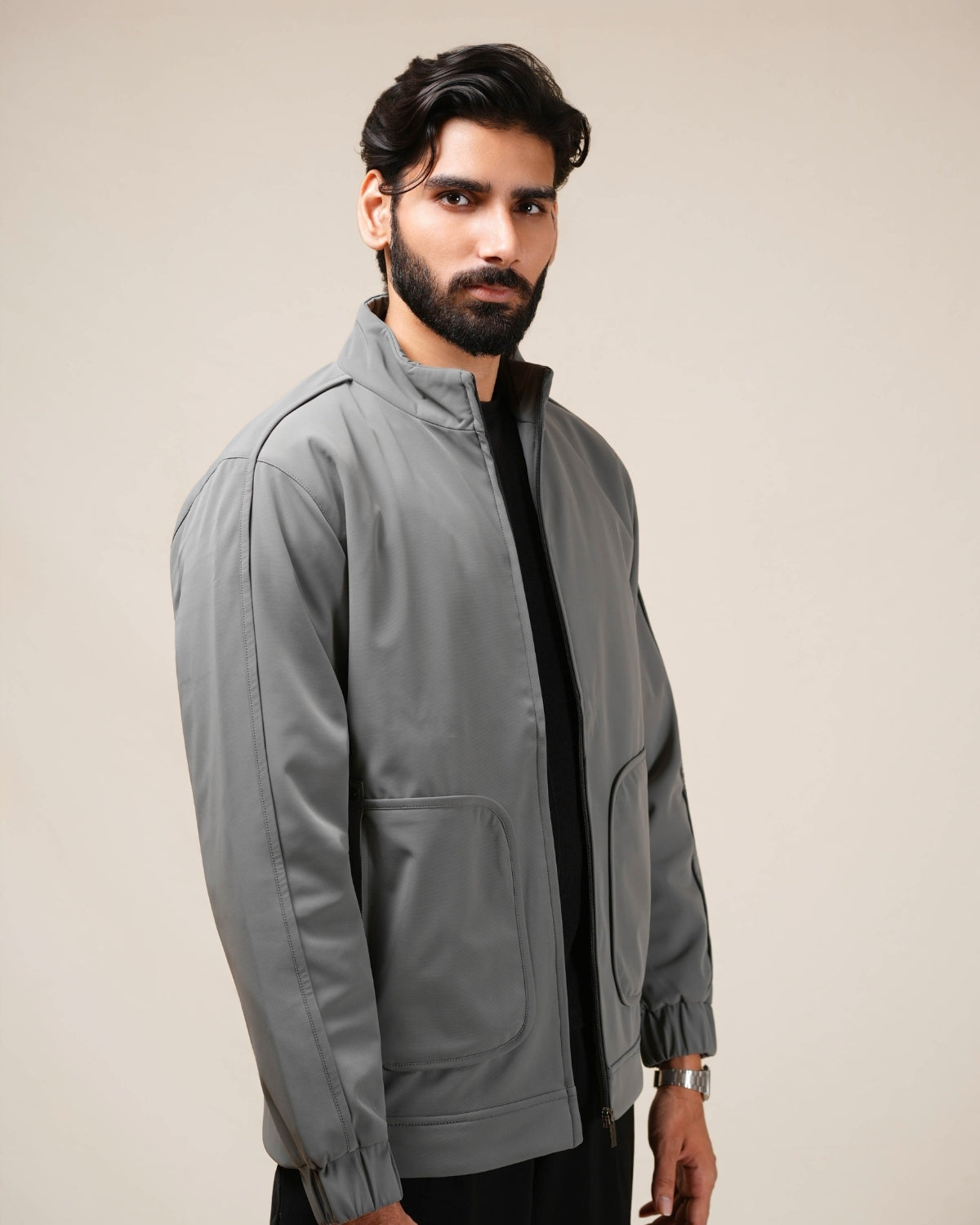 Man wearing a gray jacket against a plain background