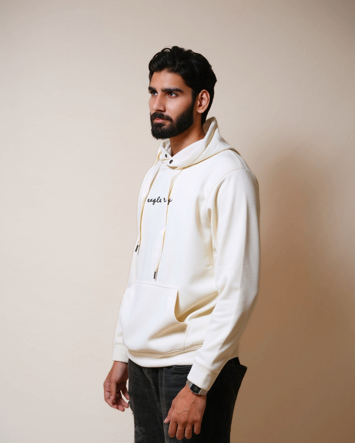 Man wearing a white hoodie with text on a beige background