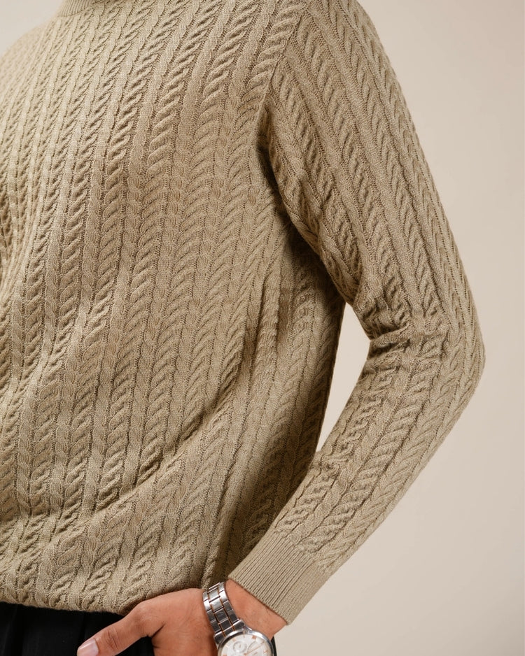 Beige cable knit sweater worn by a person with a neutral background