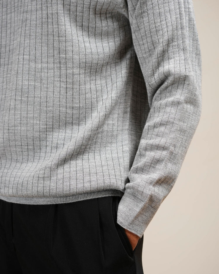 Man wearing a gray checkered long-sleeve shirt against a beige background