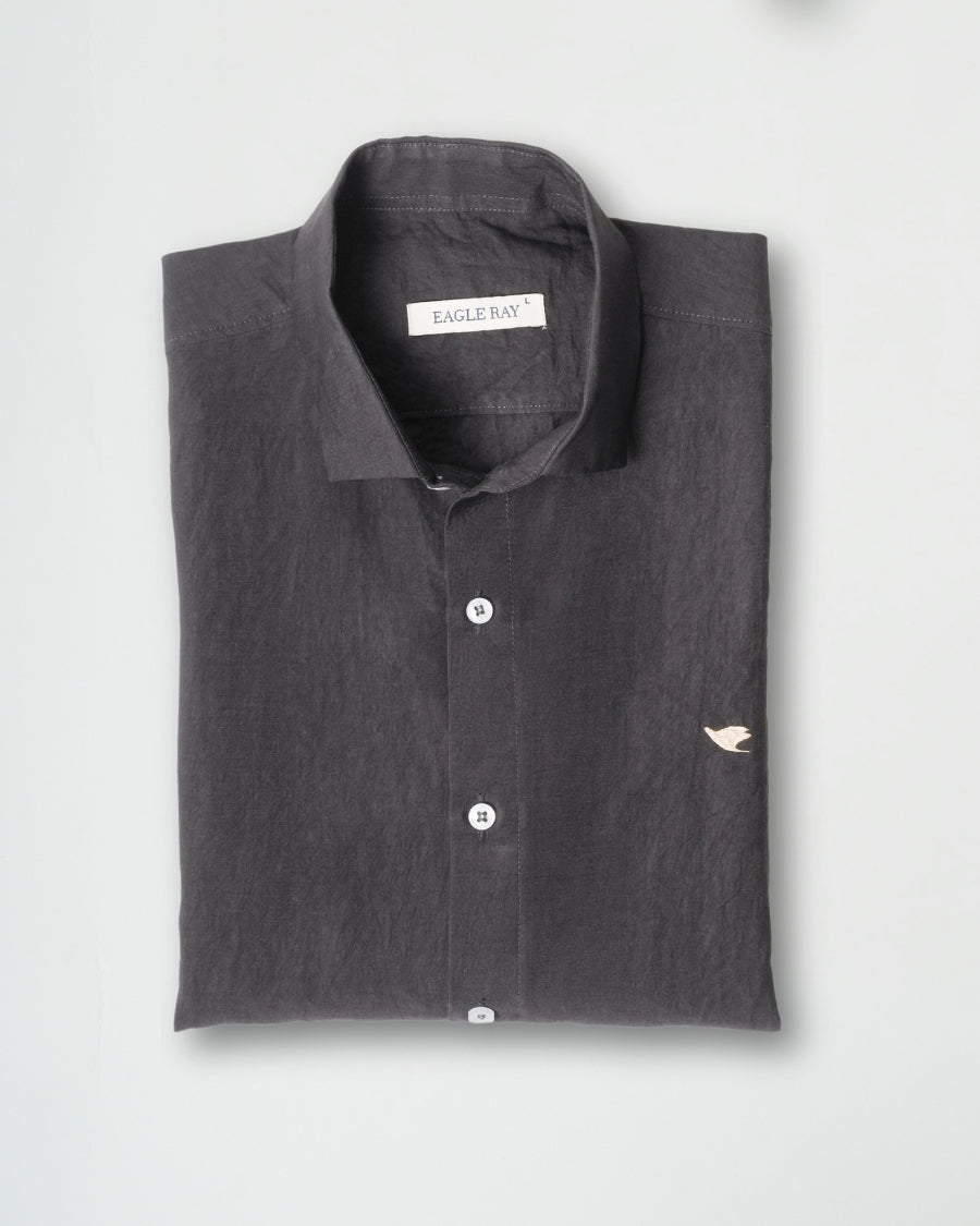 Folded dark gray polo shirt with a brand label on a light gray background