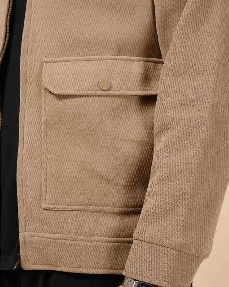 Man wearing a beige jacket against a plain background