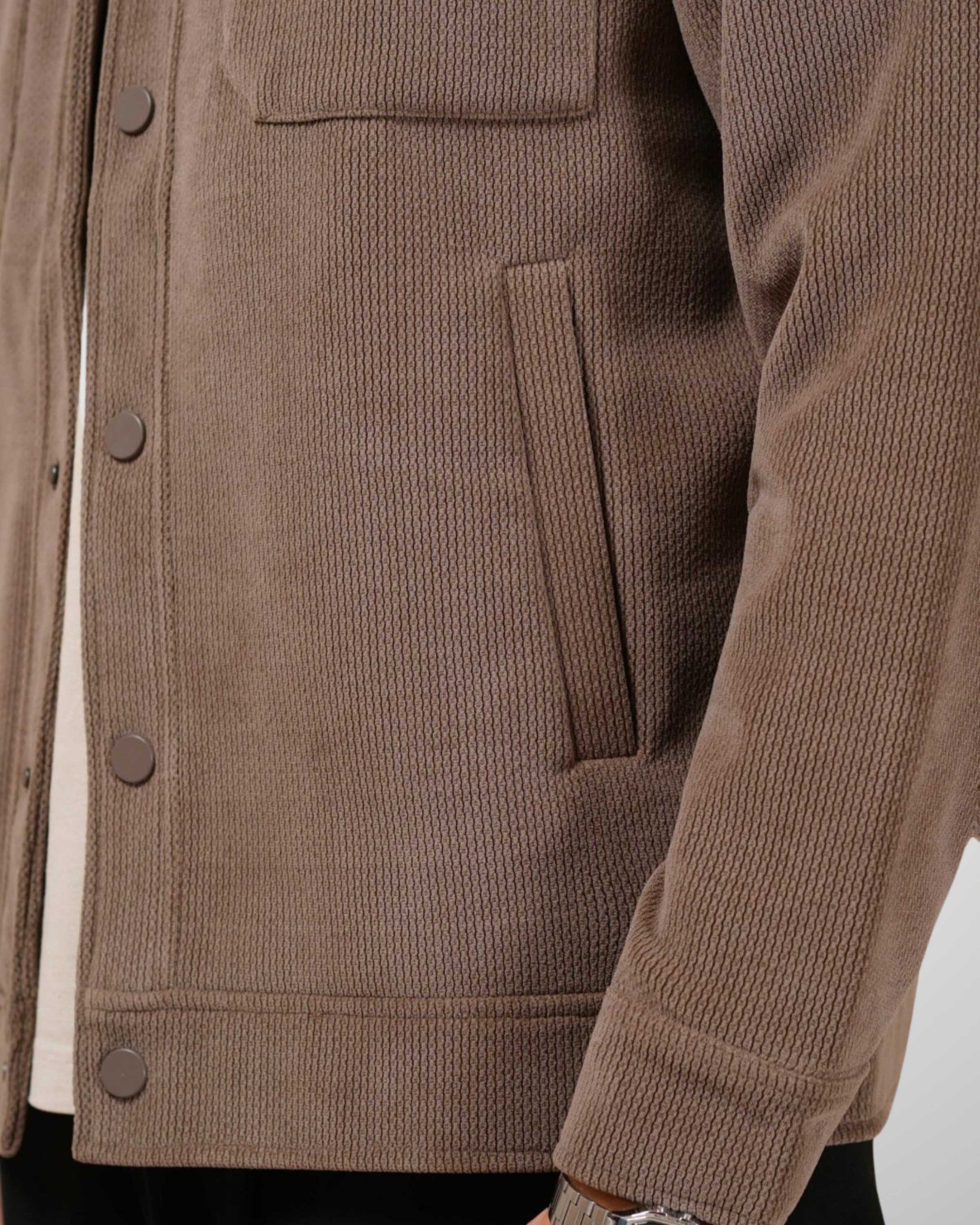 Brown corduroy jacket with button details on a white background
